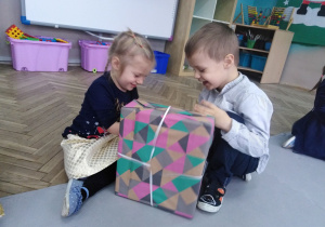 Chłopiec i dziewczynka trzyma zapakowany prezent