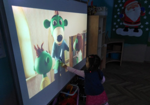 dziecko porusza długopisem po tablicy interaktywnej
