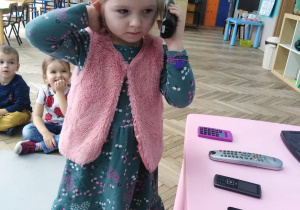 dziewczynka trzyma słuchawkę telefonu i przykłada do ucha
