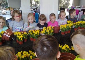 dzieci przy wielkim stole z kwiatami
