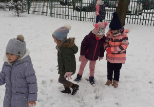 grupa dzieci chodzi po śniegu