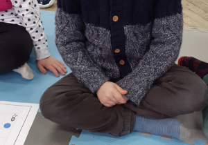 chłopiec siedzący przed kartką z guzikami