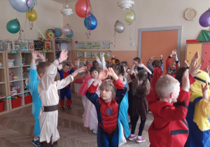 grupa dzieci tańcząca i wznosząca ręce nad głową