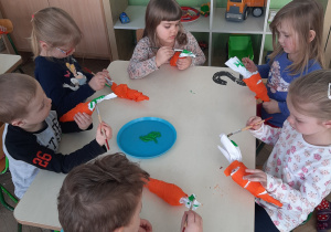 dzieci robia marchewki przy stole