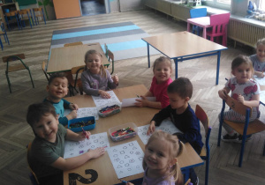 grupa dzieci koloruje figury