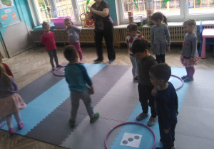dzieci stoją przy obręczy hula hop