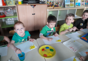 4 chłopców maluje farbami zwiastuny wiosny