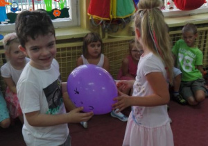 chłopiec z balonem i dziewczynką tańczą