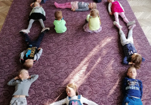 Dzieci tworzą razem dom na dywanie
