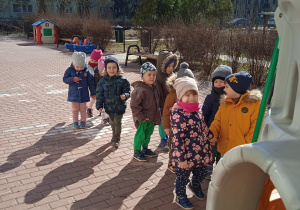 Dzieci stoją w grupie na tarasie