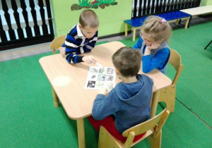 dzieci patrzą na kartę z obrazkami