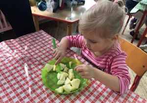 dziewczynka w skupieniu kroi