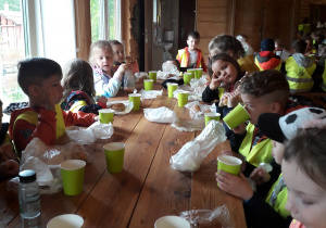 Grupa dzieci spożywa posiłek
