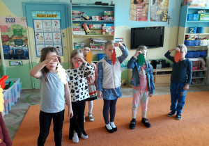Dzieci wspólnie stoją w grupie i wykonują ćwiczenia oddechowe