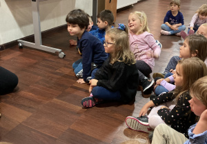Dzieci siedzą w kole na podłodze