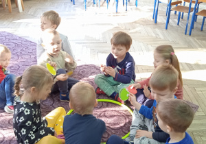 Dzieci wspólnie siedzą na dywanie