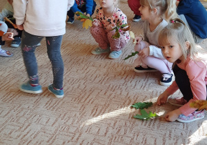 Dzieci w grupie siedzą na dywanie