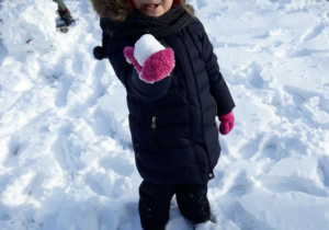 dziewczynka trzyma kulkę śniegową