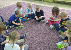 Dzieci siedzą w kole na dywanie