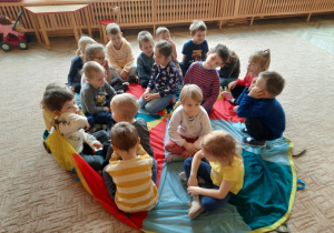 Dzieci siedzą razem na chuście