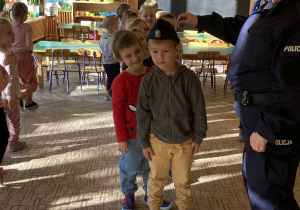 Dzieci przymierzają czapkę policyjną