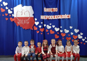 Dzieci stoją na tle syboli Polski