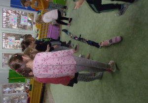 Dzieci stoją z butami ustawionymi jeden za drugim