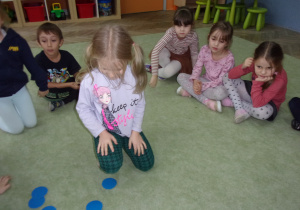 Dzieci siedzą na dywanie z wspólnie bawią się