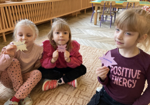 Dzieci siedzą na dywanie trzymają gwiazdki