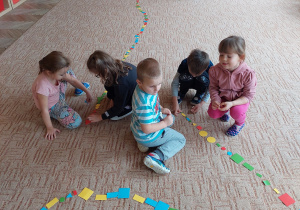 Dzieci wspólnie układają kolorowe karteczki