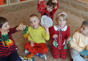 Dzieci trzymają w ręku ozdoby choinkowe