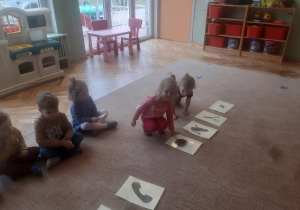 Dzieci wykonują zadania na dywanie