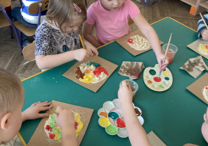 Dzieci wspólnie siedzą przy stoliku i wykonują zadanie- pizzę z masy solnej