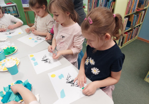 Dziewczynki naklejają kolorowy papier na swoje prace
