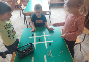 Dzieci grają na blacie stolika w kółko i krzyżyk