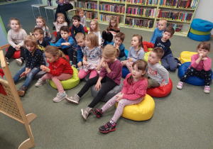 dzieci siedza na dywanie w bibiliotece
