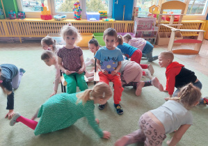 Dzieci bawią się w spólnie na dywanie