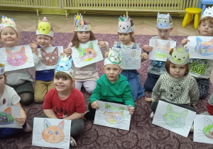 Grupa dzieci prezentuje wykonane przez siebie prace plastyczne