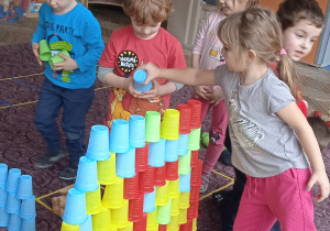 Wspólna zabawa w budowanie sciany z plastikowych kubeczków