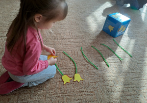 Dziewczynka składa papierowego kwiatka