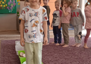 Chłopiec stoi bosymi stopami w plastikowym pojemniku