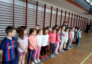 Dzieci stoją przy drabinkach gotowe do wykonywania ćwiczeń