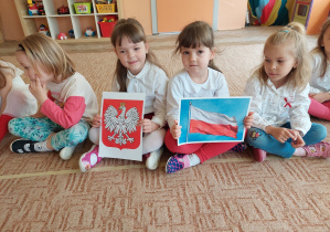 Dwie dziewczynki trzymają flagę Polski