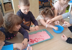Dzieci obserwują jak mąka zmienia kolor.