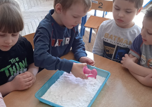 Chłopiec wlewa barwnik do mąki.