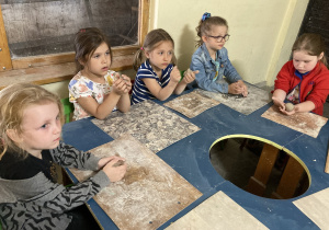 Dzieci lepią z gliny przy stole