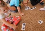 Troje dzieci siedzi na dywanie z puzzlami