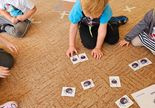 dziecko układa puzzle na dywanie
