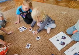 dzieci układają puzzle na dywanie