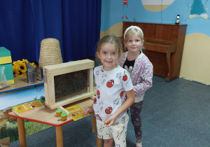 dwie dziewczynki koło wystawy związanej z tematyka pszczelarską